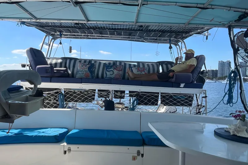 Slide: The Image of Man relaxing on Fountaine Pajot Belize 43 catamaran, enjoying waterfront view. - 22