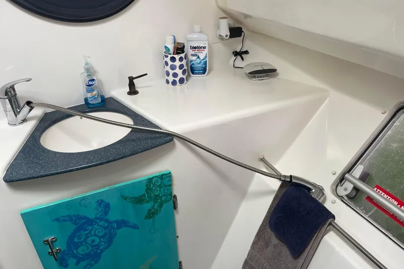 Slide: The Image of Bathroom sink area on 2000 Fountaine Pajot Belize 43 catamaran with toiletries and turtle-themed cabinet. - 28