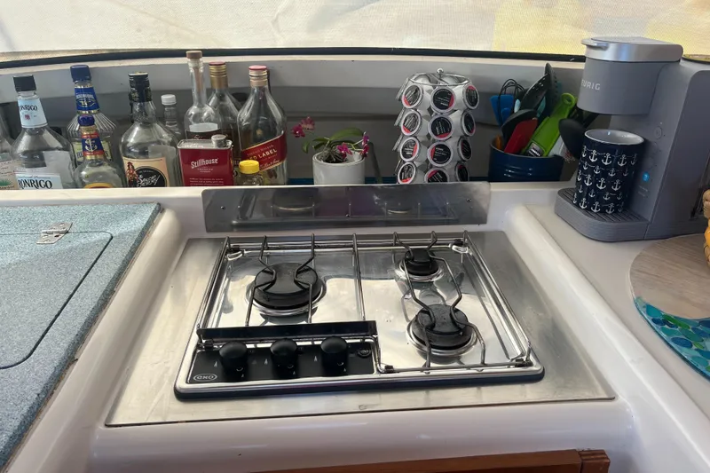 Slide: The Image of Galley kitchen in 2000 Fountaine Pajot Belize 43 with stove, bottles, and coffee maker. - 5