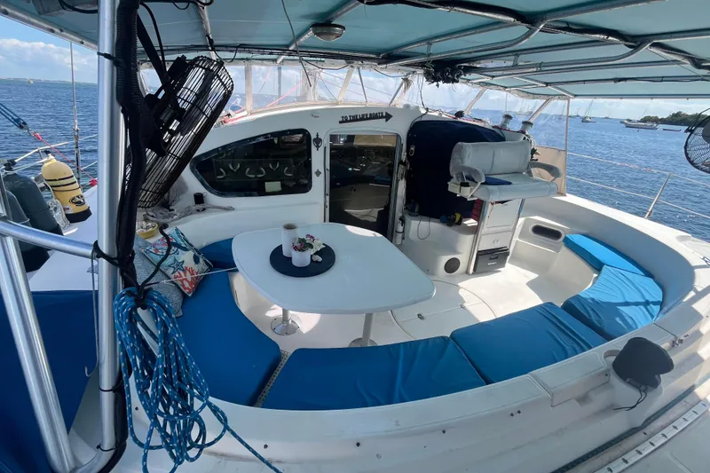 Slide: The Image of Catamaran cockpit with blue seating, table, and ocean view; Fountaine Pajot Belize 43, 2000 model. - 18