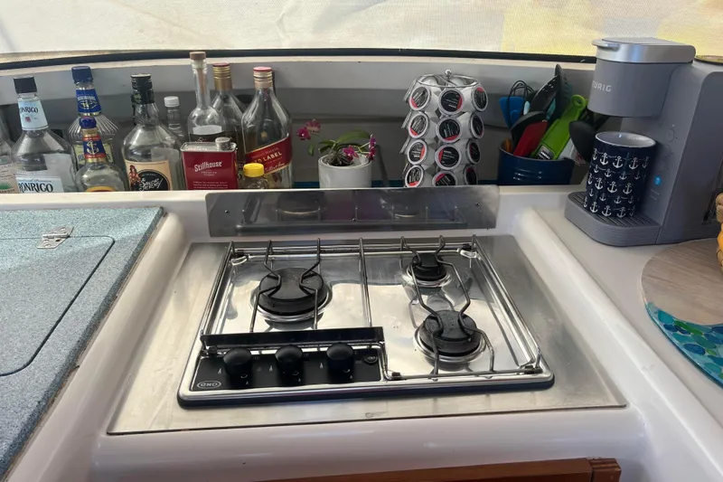 Slide: The Image of Galley kitchen in 2000 Fountaine Pajot Belize 43 with stove, coffee maker, and bottles. - 34