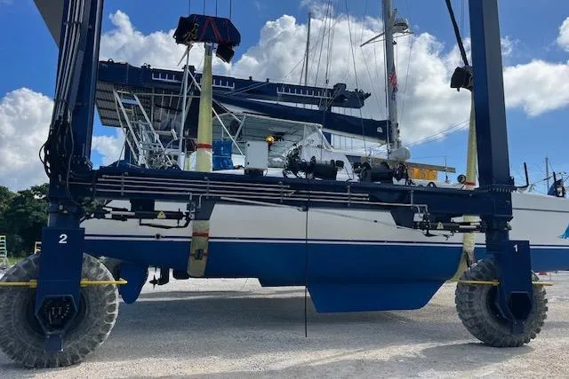 Slide: The Image of 2001 Fountaine Pajot Belize 43 catamaran on a boat lift under a clear blue sky. - 37
