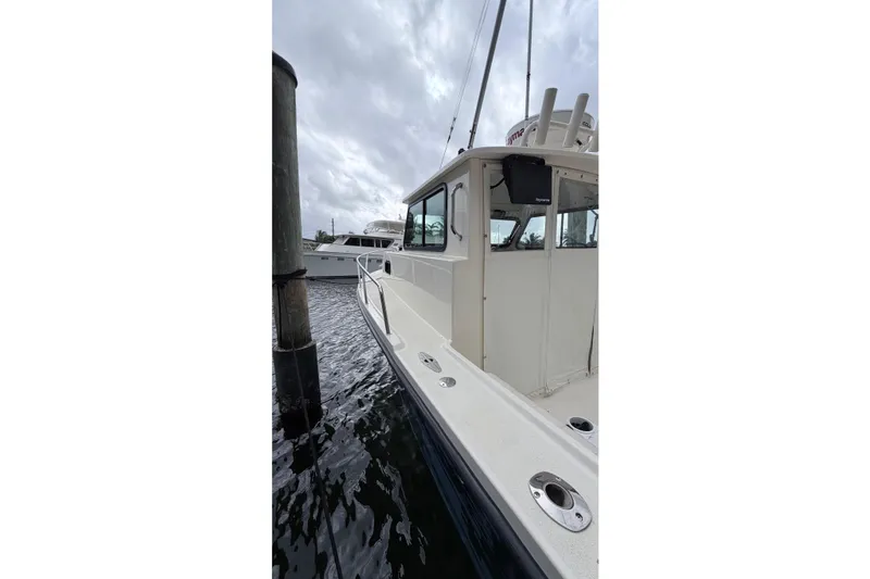 Slide: The Image of 2001 Parker 2520 Deep Vee Sport Cabin boat docked on a cloudy day. - 21