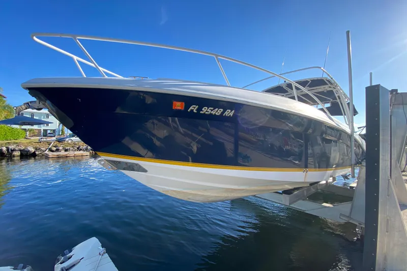 Slide: The Image of 2004 Deep Impact 36 DI boat on lift, sunny day, waterfront view. - 10