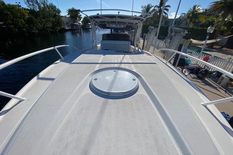 Slide: The Image of 2004 Deep Impact 36 DI boat deck with hatch, docked near palm trees and waterway. - 14