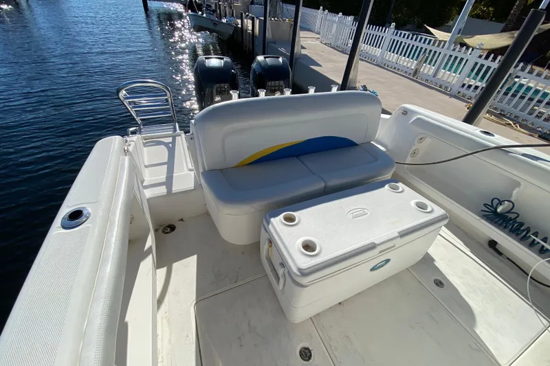 Slide: The Image of 2004 Deep Impact 36 DI boat with seating and cooler on deck, docked by the water. - 18