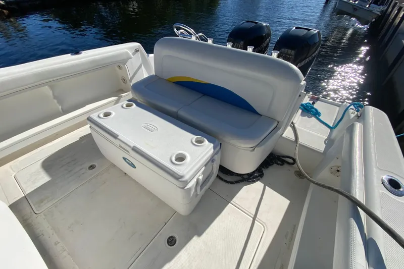 Slide: The Image of 2004 Deep Impact 36 DI boat interior with seating and cooler, docked by the water. - 19