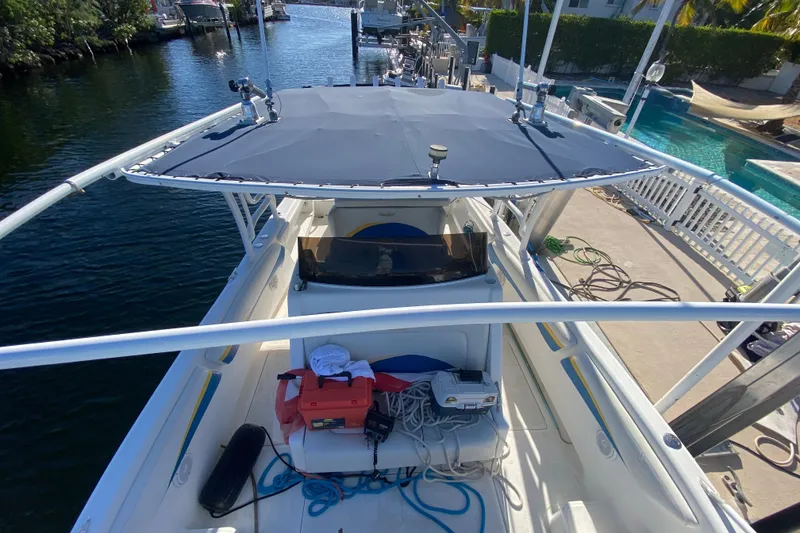 Slide: The Image of 2004 Deep Impact 36 DI boat docked, featuring a spacious deck and canopy. - 24