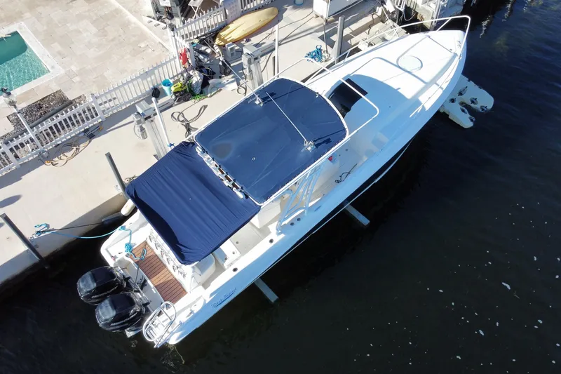 Slide: The Image of 2004 Deep Impact 36 DI boat docked, featuring dual engines and blue canopy. - 40