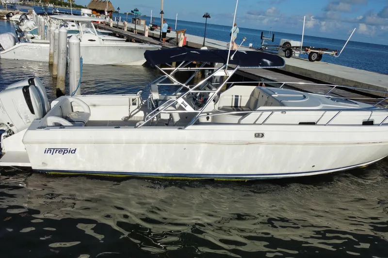 Slide: The Image of 1998 Intrepid 339 boat docked at marina under clear blue sky. - 13