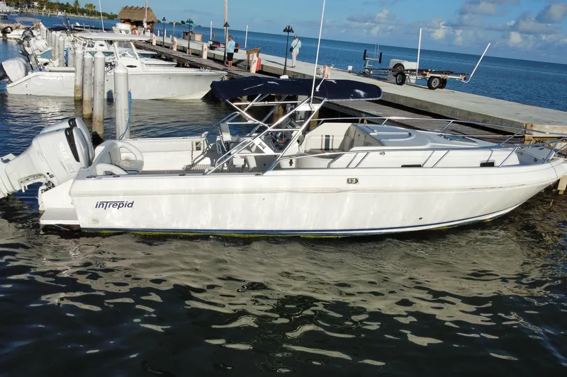 Slide: The Image of 1998 Intrepid 339 boat docked at marina, clear blue sky and calm water. - 15
