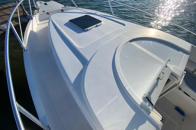 Slide: The Image of 1998 Intrepid 339 boat deck with open hatch, docked by the water. - 19