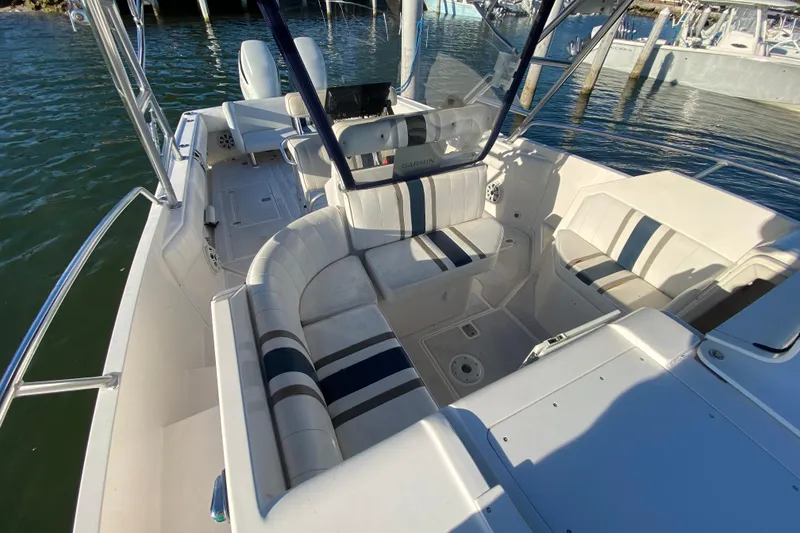 Slide: The Image of 1998 Intrepid 339 boat interior with striped seating, docked on calm water. - 23