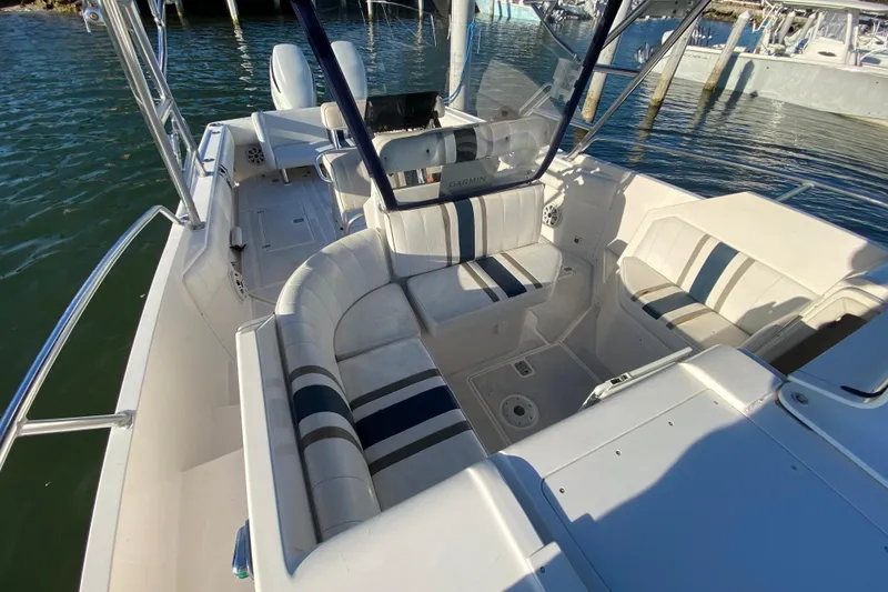 Slide: The Image of 1998 Intrepid 339 boat interior with striped seating, docked on calm water. - 24