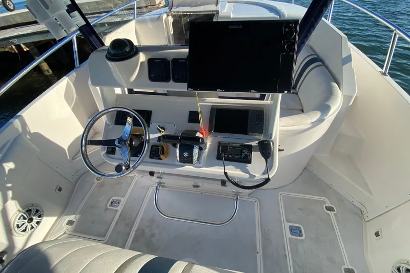 Slide: The Image of 1998 Intrepid 339 boat helm with steering wheel, navigation equipment, and seating. - 27