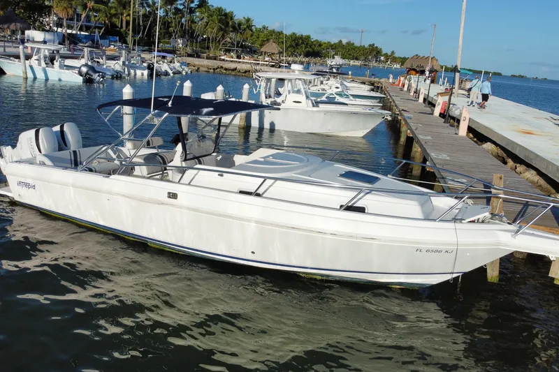 Slide: The Image of 1998 Intrepid 339 boat docked at marina, clear sky, calm water. - 3
