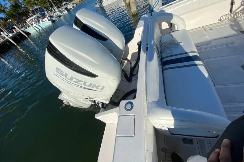 Slide: The Image of 1998 Intrepid 339 boat with twin Suzuki outboard engines docked at marina. - 30