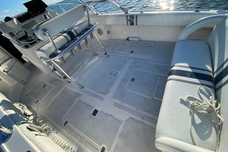 Slide: The Image of 1998 Intrepid 339 boat interior with seating, storage, and steering wheel, on calm water. - 34