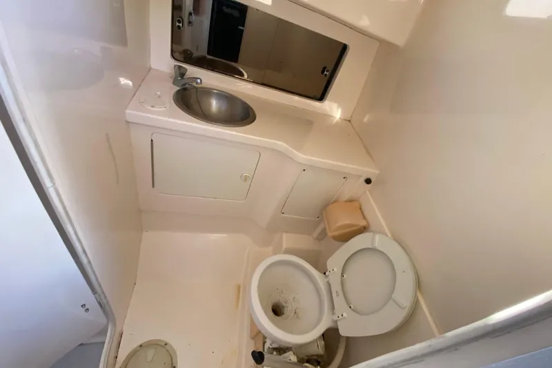Slide: The Image of 1998 Intrepid 339 boat bathroom with sink, toilet, and mirror. - 39
