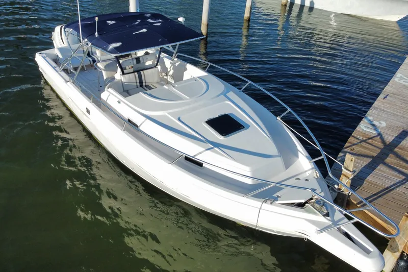 Slide: The Image of 1998 Intrepid 339 boat docked, featuring sleek design and spacious deck. - 4