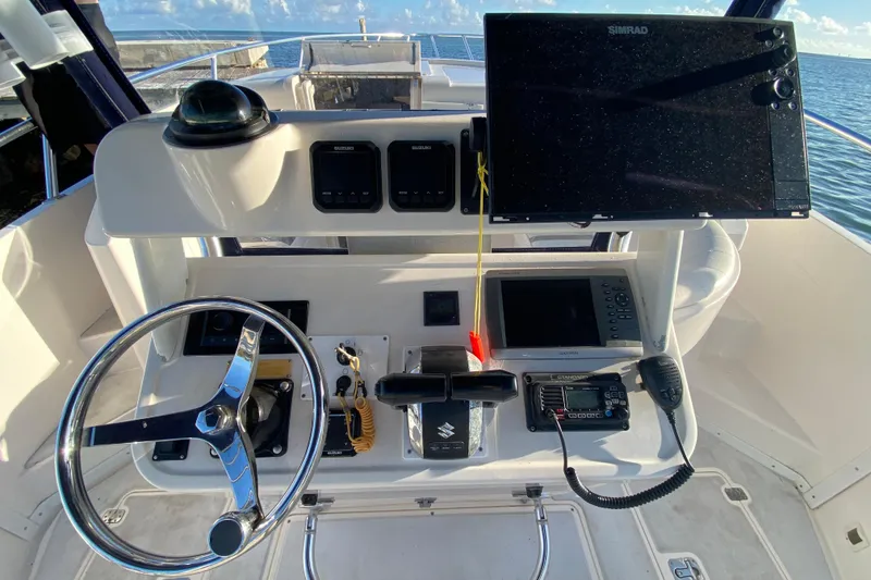 Slide: The Image of 1998 Intrepid 339 helm with steering wheel, navigation screens, and ocean view. - 42