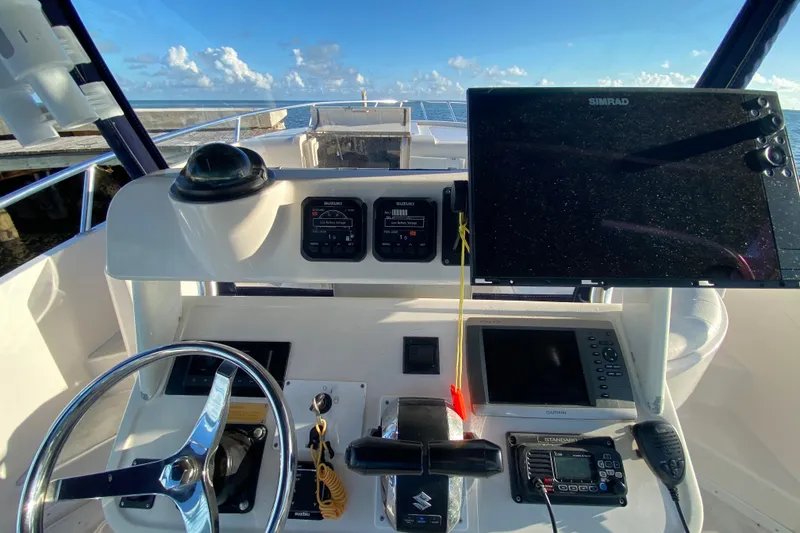 Slide: The Image of Cockpit view of 1998 Intrepid 339 boat with navigation equipment and steering wheel. - 43