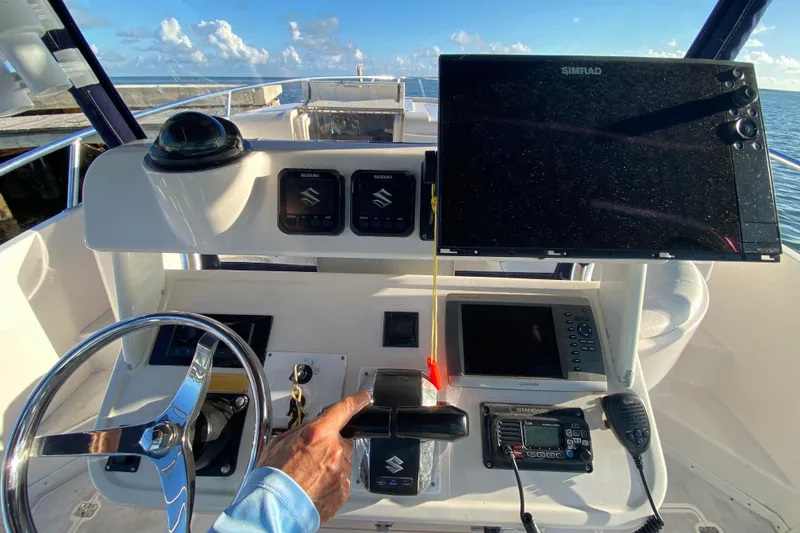 Slide: The Image of 1998 Intrepid 339 boat dashboard with steering wheel, navigation screens, and control panel. - 44