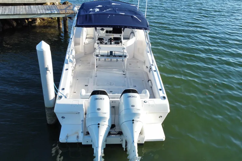 Slide: The Image of 1998 Intrepid 339 boat with twin 300 horsepower engines docked on calm water. - 46