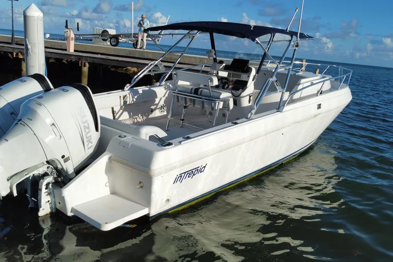 Slide: The Image of 1998 Intrepid 339 boat docked with Suzuki outboard engines, under clear skies. - 47