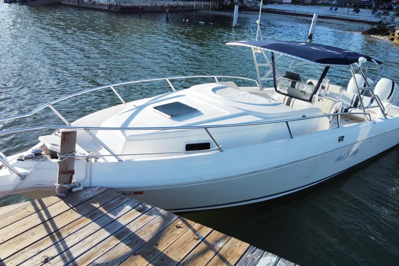 Slide: The Image of 1998 Intrepid 339 boat docked on calm water with a blue canopy. - 6