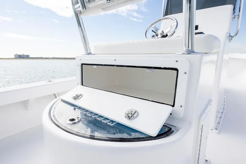 Slide: The Image of Privateer ROAMER II 2026 boat console with open storage compartment, steering wheel, and ocean view. - 10