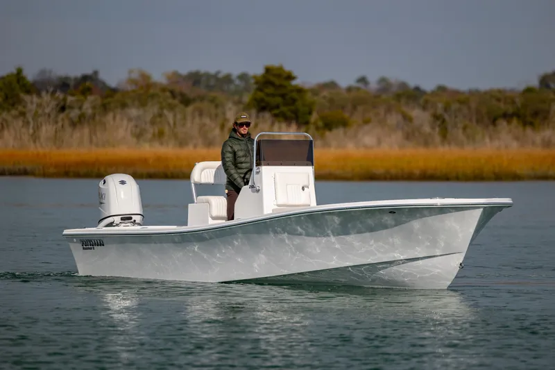Slide: The Image of Privateer ROAMER II 2026 boat on calm water with a person at the helm. - 5