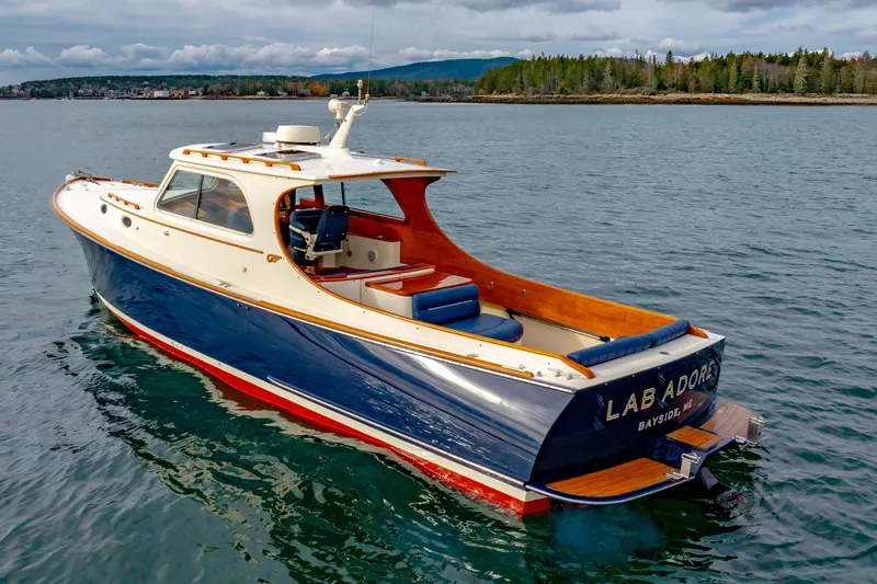 Slide: The Image of 2003 Hinckley Picnic Boat EP on serene water with scenic background. - 20