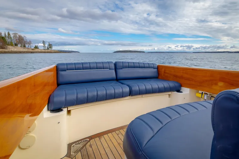 Slide: The Image of 2003 Hinckley Picnic Boat EP with blue seating, wooden accents, and scenic ocean view. - 22