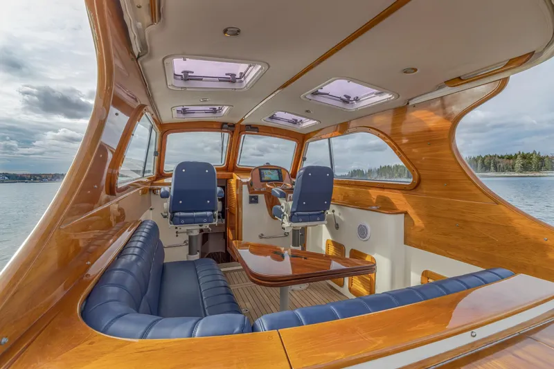 Slide: The Image of 2003 Hinckley Picnic Boat EP interior with elegant wood finish and blue seating. - 26