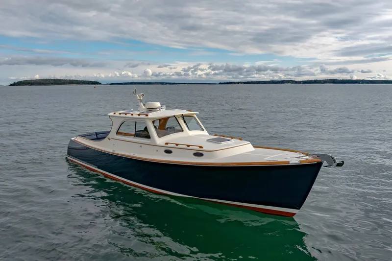 Slide: The Image of 2003 Hinckley Picnic Boat EP on calm waters under cloudy sky. - 3