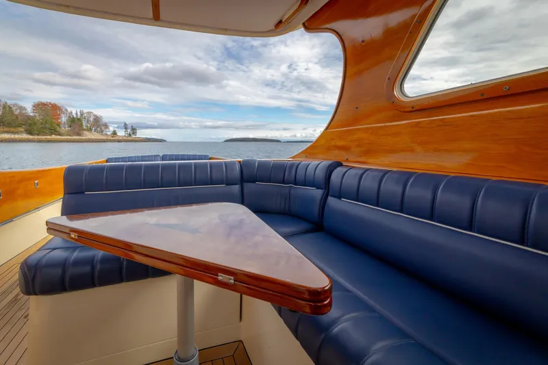 Slide: The Image of Luxurious interior of 2003 Hinckley Picnic Boat EP with blue seating and wooden table. - 30