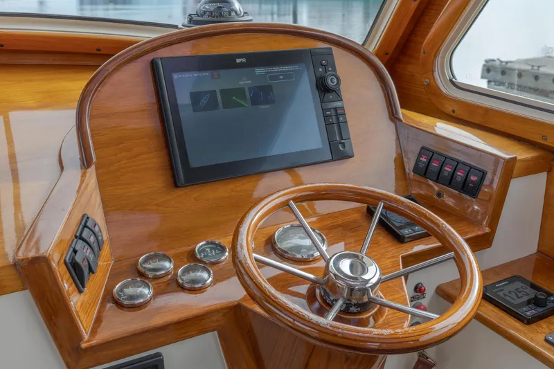 Slide: The Image of 2003 Hinckley Picnic Boat EP helm with wooden dashboard and modern navigation equipment. - 32