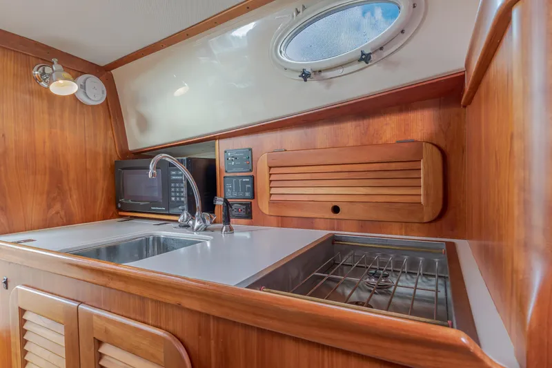 Slide: The Image of 2003 Hinckley Picnic Boat EP interior kitchen with sink, stove, and microwave. - 35