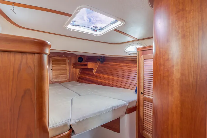 Slide: The Image of Interior of 2003 Hinckley Picnic Boat EP with wooden finish and cozy sleeping area. - 38