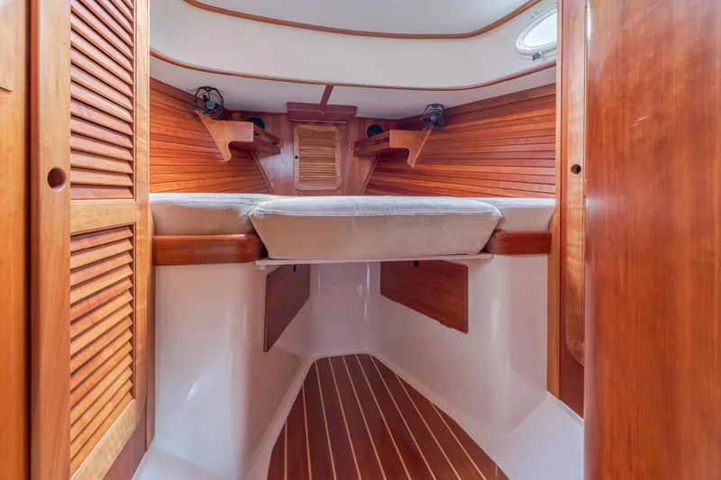 Slide: The Image of Interior of 2003 Hinckley Picnic Boat EP with wooden finishes and cozy sleeping area. - 40