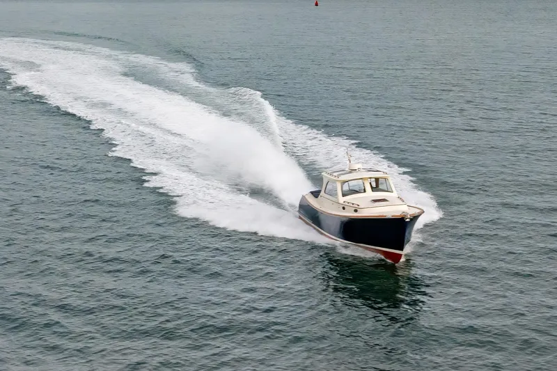Slide: The Image of 2003 Hinckley Picnic Boat EP cruising on open water, leaving a wake. - 8