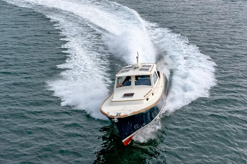 Slide: The Image of 2003 Hinckley Picnic Boat EP cruising on open water, creating a dynamic wake. - 10