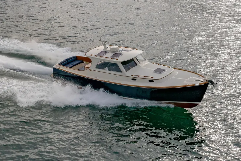 Slide: The Image of 2003 Hinckley Picnic Boat EP cruising on water, showcasing elegant design and performance. - 13