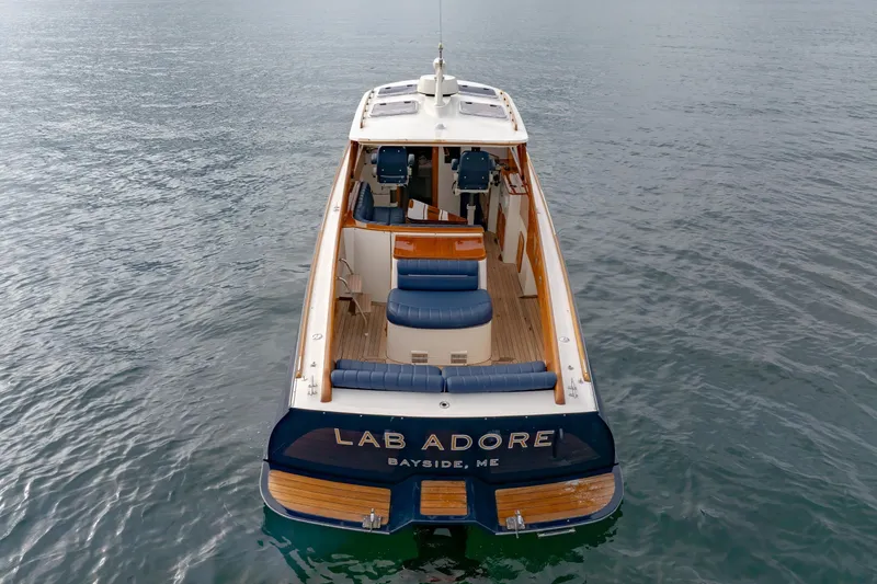 Slide: The Image of 2003 Hinckley Picnic Boat EP on water, rear view with seating and helm. - 16