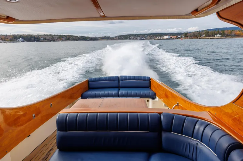 Slide: The Image of 2003 Hinckley Picnic Boat EP cruising on open water, featuring elegant seating and wooden finishes. - 27