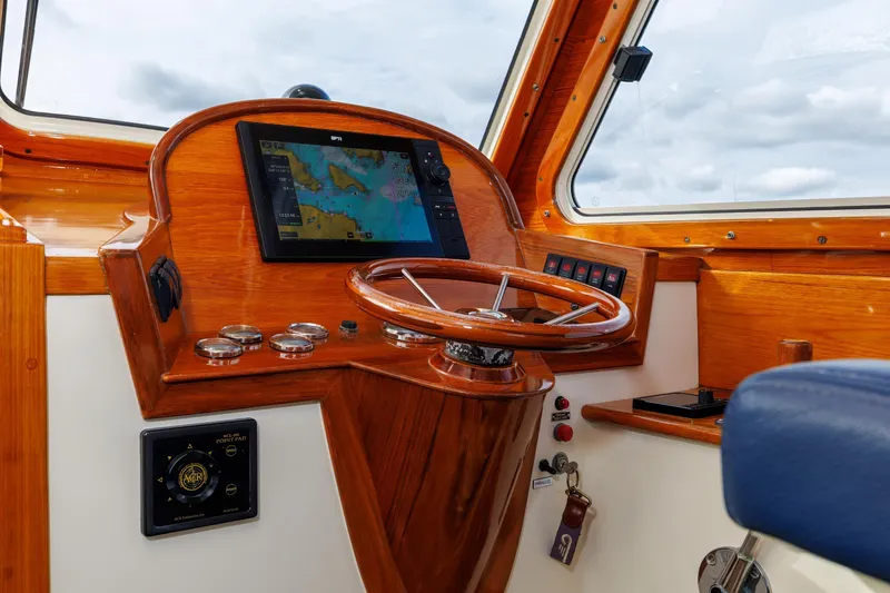 Slide: The Image of 2003 Hinckley Picnic Boat EP helm with wooden dashboard and navigation screen. - 31