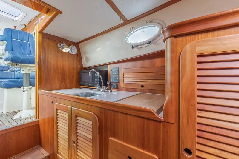 Slide: The Image of 2003 Hinckley Picnic Boat EP interior with wooden cabinetry and modern amenities. - 34