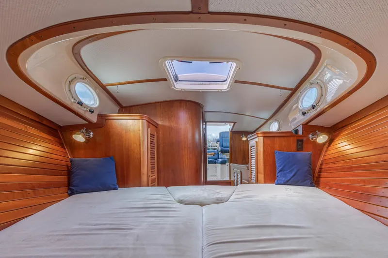 Slide: The Image of Interior of 2003 Hinckley Picnic Boat EP with wooden paneling and cozy bedding. - 41