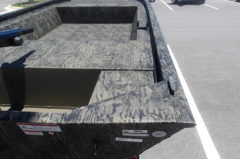 Slide: The Image of 2026 Tracker Grizzly 1648 SC boat with camouflage pattern in a parking lot. - 3